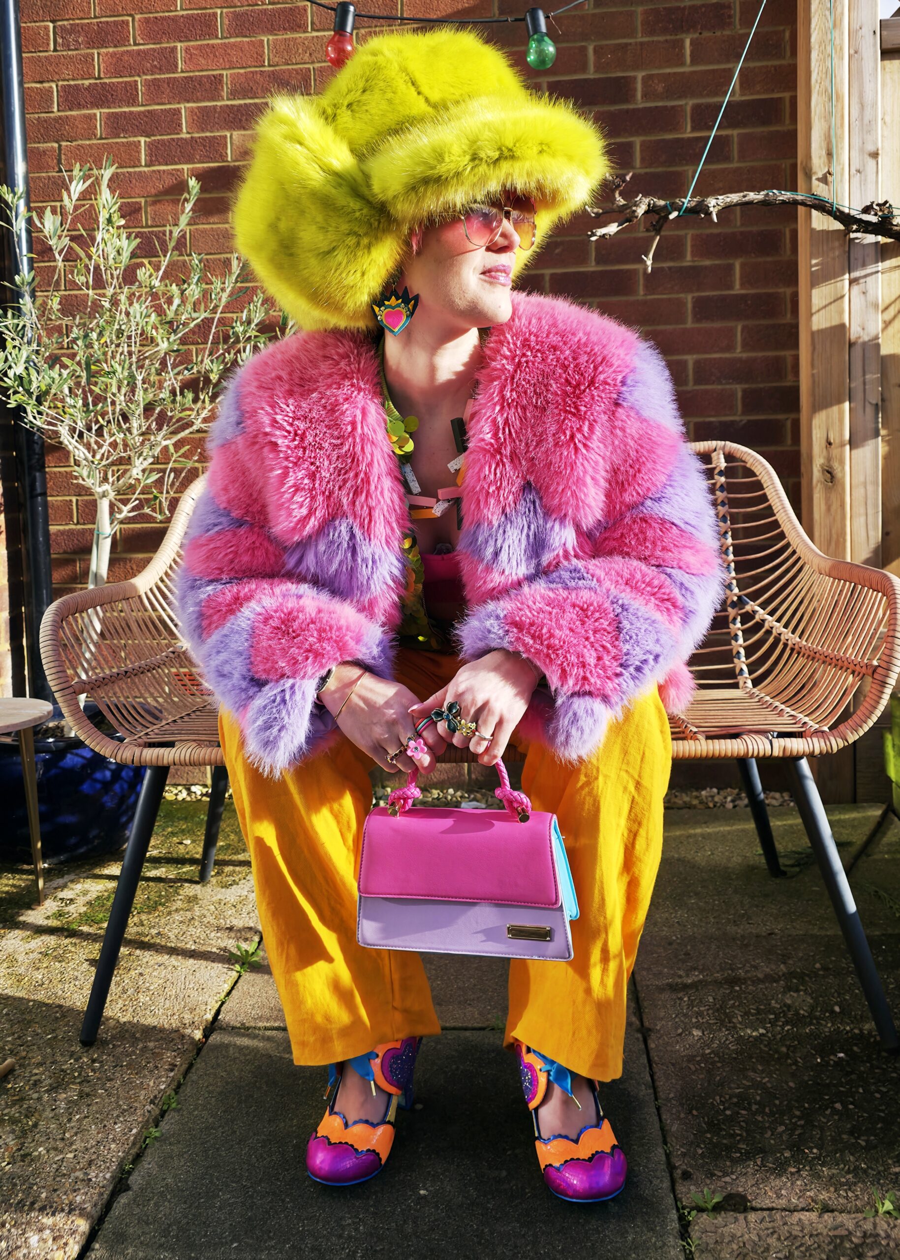 adeline sitting on a bench in a big hat.
